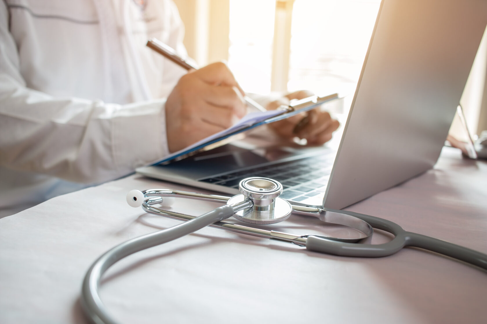 Medicine doctor's writing on laptop in medical office Focus stet