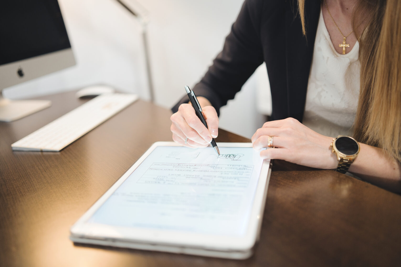 Close up of a psychologist signing a document on a digital tablet in her office