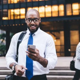 Curious black businessman using smartphone
