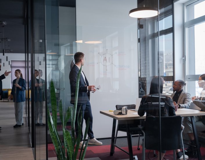 Modern office meeting with diverse professionals discussing artificial intelligence strategy Concept of teamwork, technology, and corporate innovation in a contemporary workspace